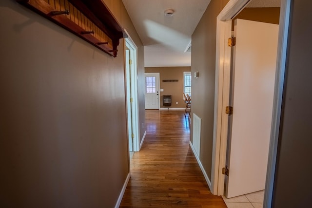 hall with baseboards and light wood finished floors