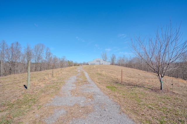 view of street with a pole building, a rural view, and driveway