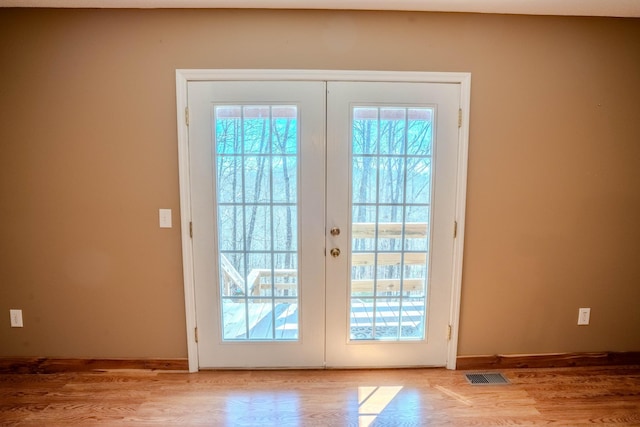 entryway featuring french doors, visible vents, light wood-style flooring, and baseboards