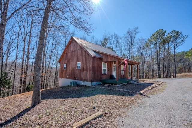 view of side of property with metal roof and central AC