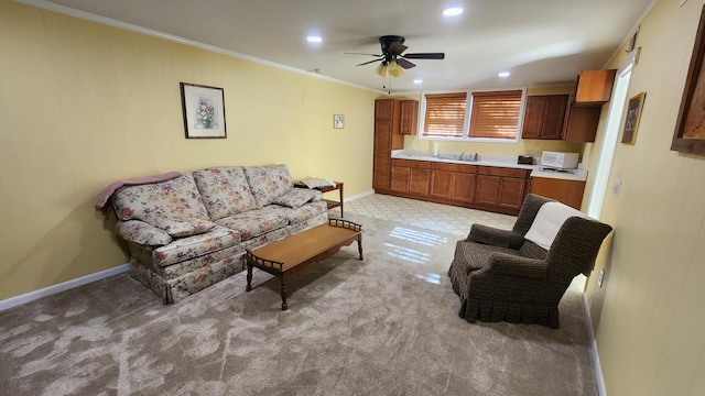 living room with recessed lighting, light carpet, a ceiling fan, baseboards, and crown molding