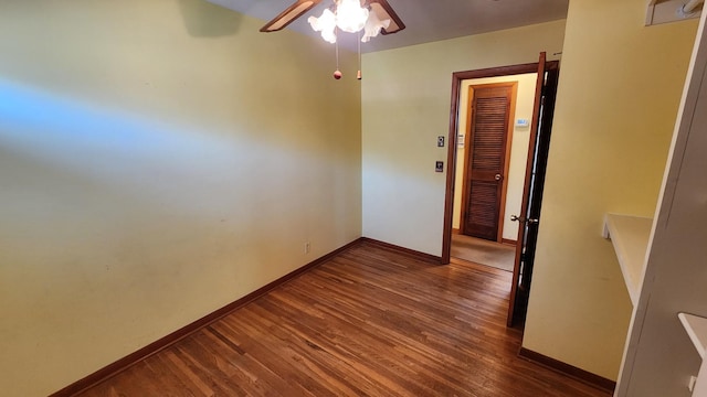 unfurnished room featuring a ceiling fan, baseboards, and wood finished floors