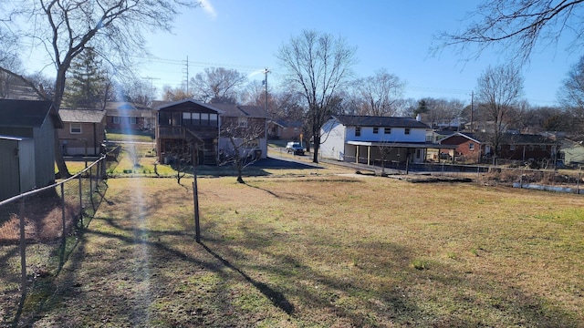 view of yard with stairs, fence, and a residential view