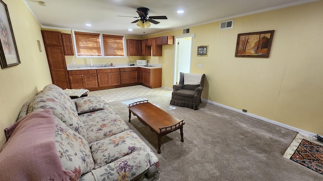 living area featuring light carpet, baseboards, visible vents, and crown molding