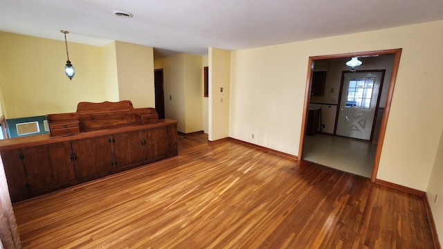 interior space featuring wood finished floors, visible vents, and baseboards