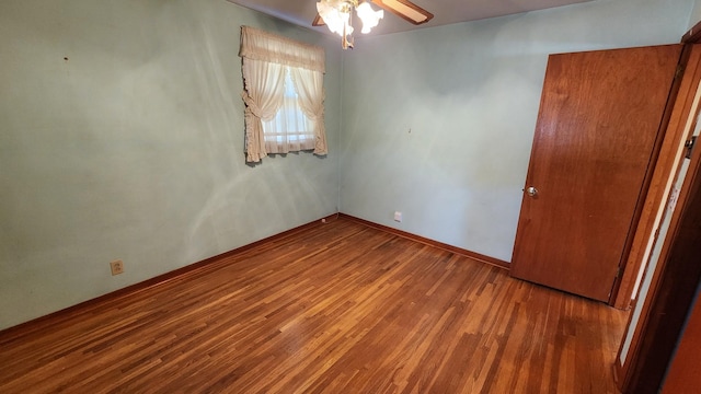 unfurnished room featuring a ceiling fan, baseboards, and wood finished floors