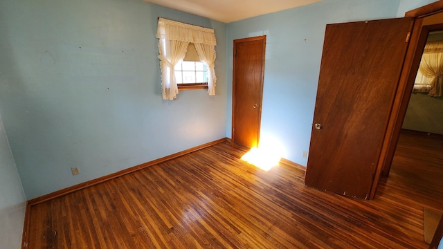 empty room featuring baseboards and wood finished floors