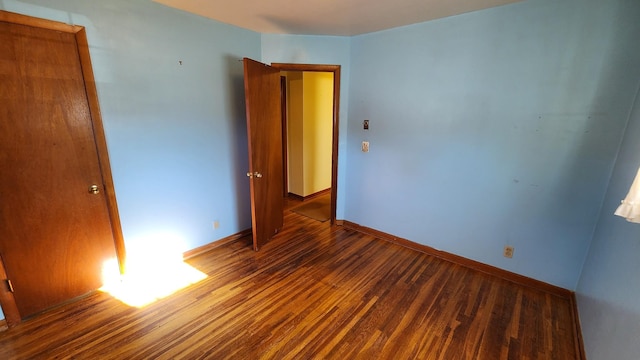 empty room with baseboards and wood finished floors