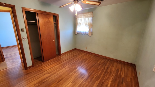 unfurnished bedroom featuring a closet, baseboards, and wood finished floors