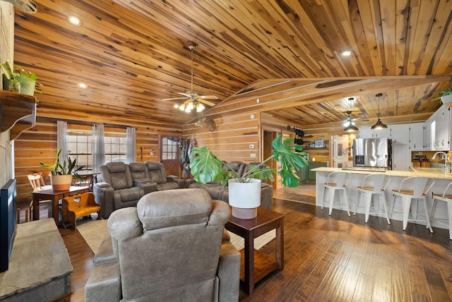 living room featuring dark wood-type flooring, vaulted ceiling, wood walls, ceiling fan, and wooden ceiling