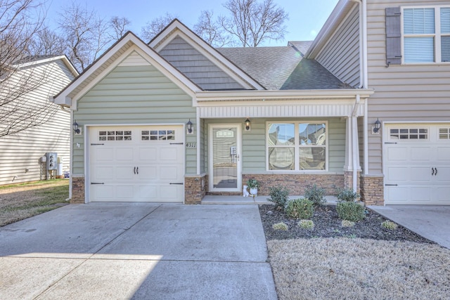 view of front of home featuring stone siding, concrete driveway, roof with shingles, and an attached garage