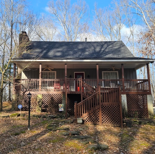 rear view of property with board and batten siding, stairs, a porch, and ceiling fan