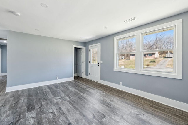 interior space featuring dark wood-type flooring, visible vents, and baseboards