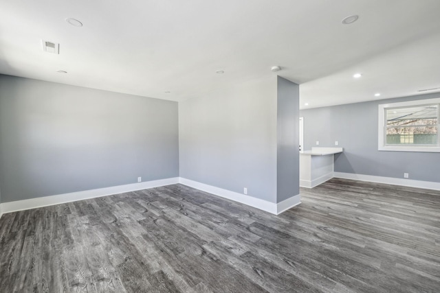 empty room featuring visible vents, baseboards, wood finished floors, and recessed lighting