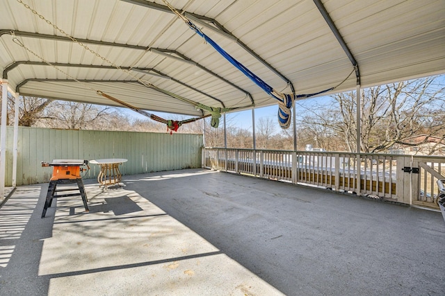 view of patio / terrace featuring fence and a carport