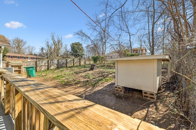 wooden deck featuring an outdoor structure and fence