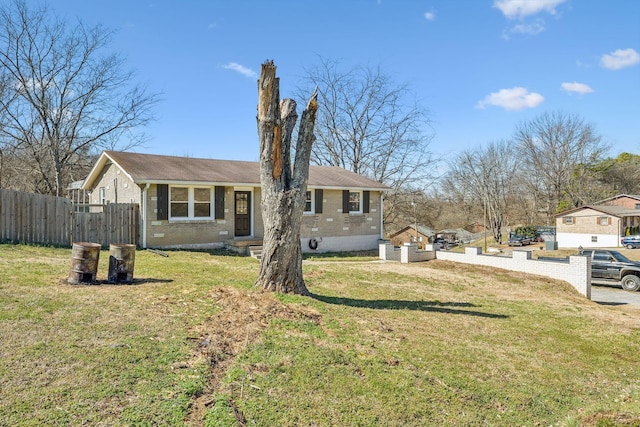 exterior space with a yard, brick siding, and fence