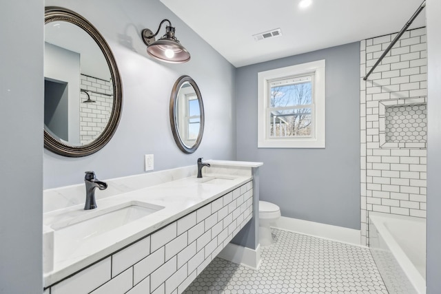 bathroom featuring toilet, visible vents, a sink, and tile patterned floors