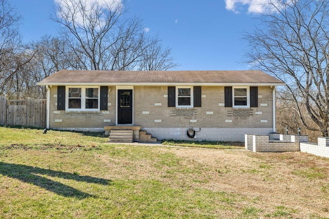 view of front of house featuring brick siding, fence, and a front yard