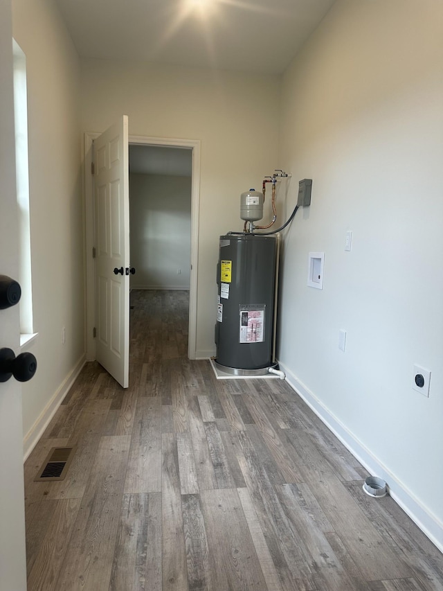 utility room featuring water heater and visible vents