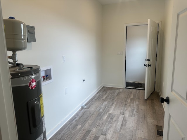 laundry area featuring laundry area, visible vents, wood finished floors, electric water heater, and washer hookup