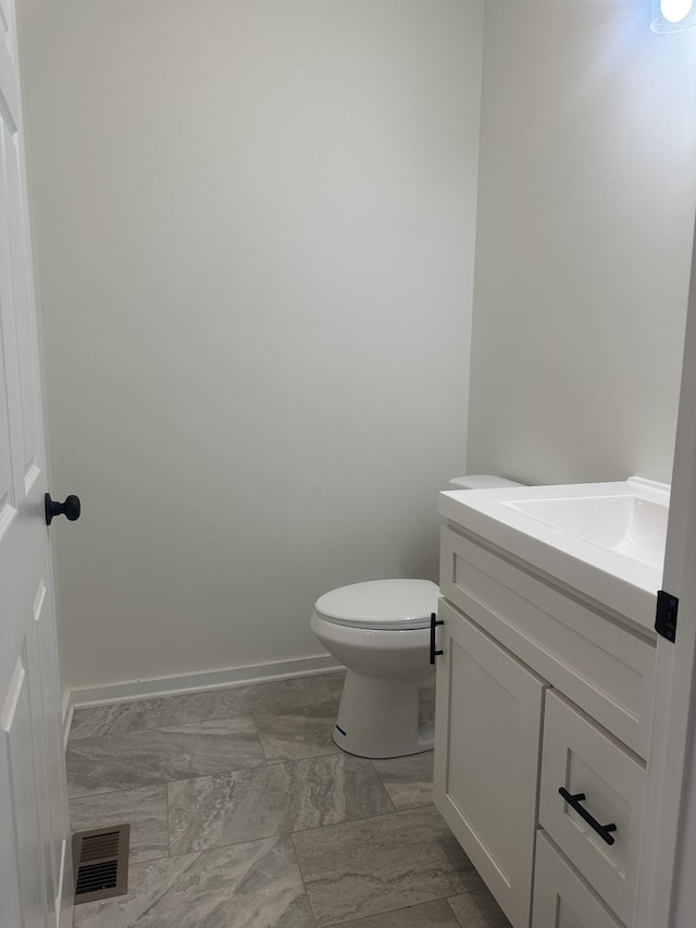 bathroom featuring baseboards, visible vents, toilet, marble finish floor, and vanity