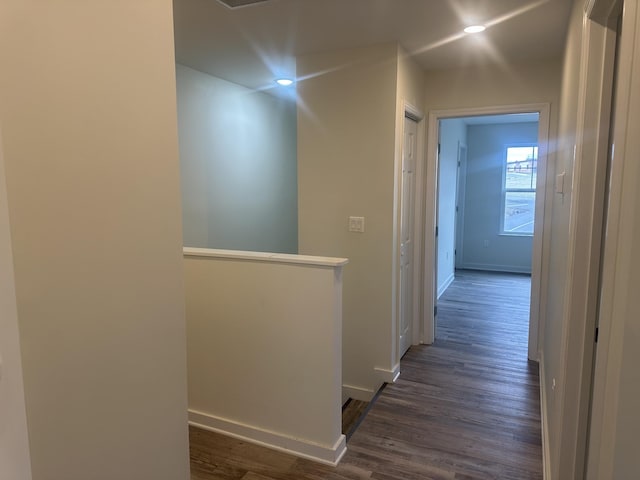 hall with dark wood-style flooring, recessed lighting, an upstairs landing, and baseboards