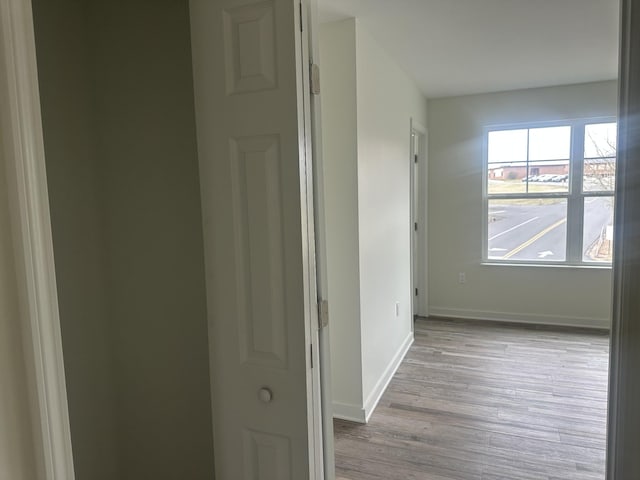 hallway featuring baseboards and wood finished floors