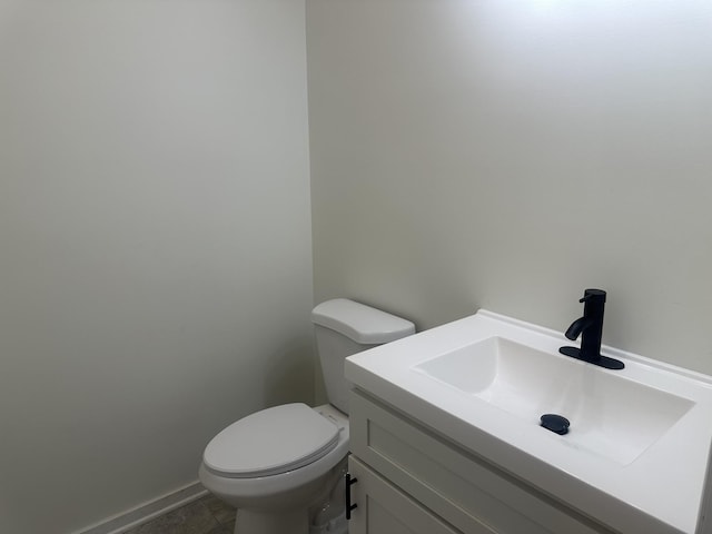 bathroom featuring vanity, toilet, and baseboards