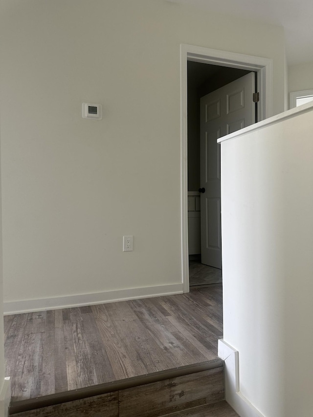 empty room with baseboards and wood finished floors