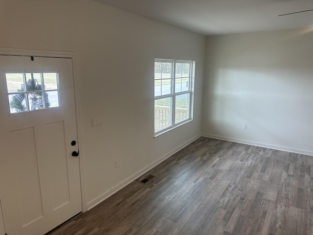 foyer with dark wood-style floors, visible vents, and baseboards