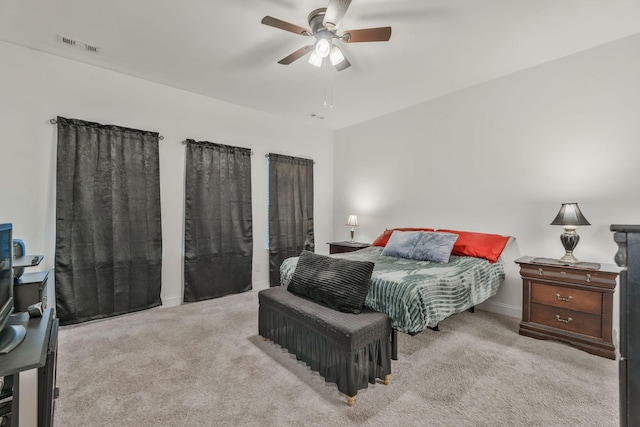 carpeted bedroom featuring a ceiling fan and visible vents