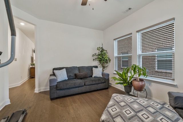 living room featuring baseboards, visible vents, and wood finished floors