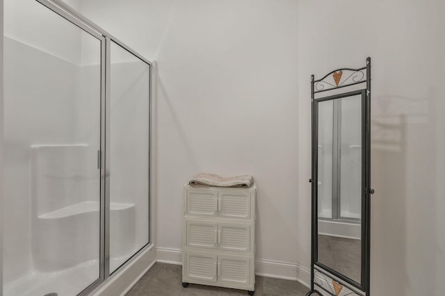 full bathroom featuring tile patterned flooring, a shower stall, and baseboards