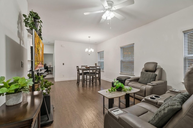 living area featuring baseboards, wood finished floors, and ceiling fan with notable chandelier