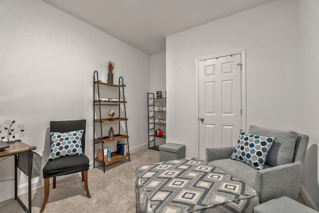 living area featuring light carpet and baseboards