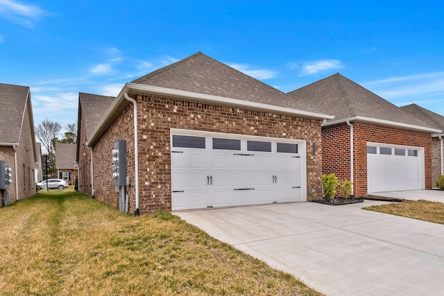 view of home's exterior featuring brick siding, a yard, an attached garage, and roof with shingles