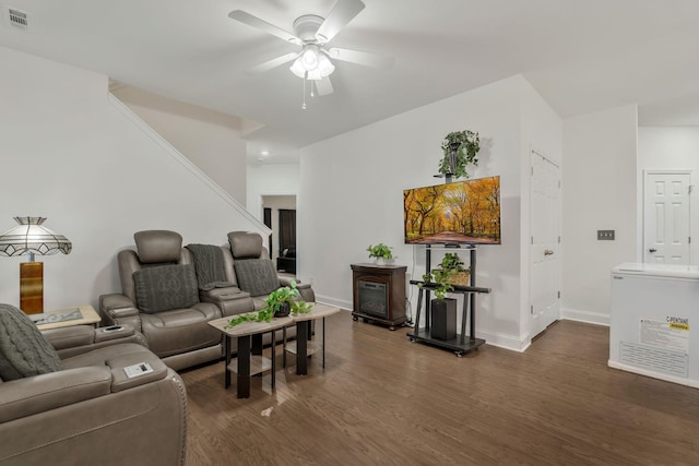 living area with visible vents, wood finished floors, a ceiling fan, and baseboards