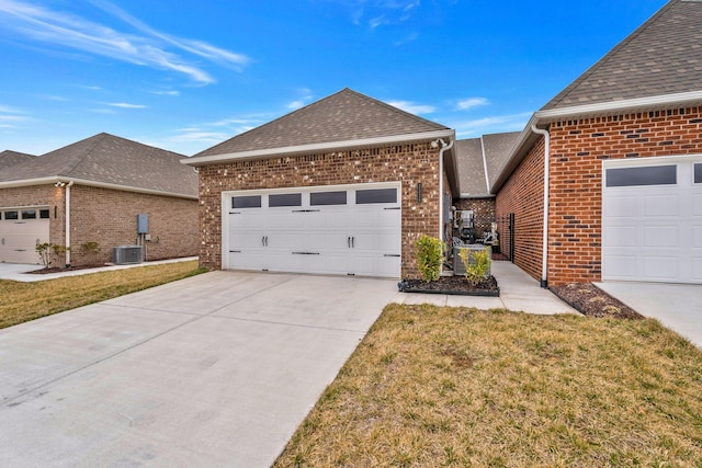 view of front facade with brick siding, roof with shingles, a garage, driveway, and a front lawn