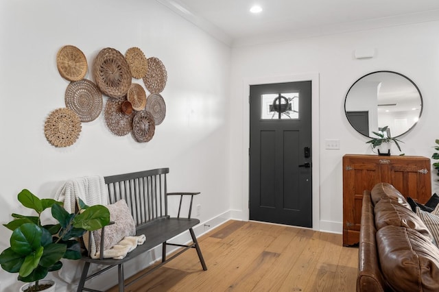 foyer with recessed lighting, baseboards, crown molding, and light wood finished floors