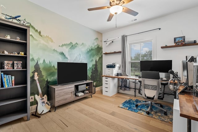 office space featuring a ceiling fan, visible vents, and wood finished floors