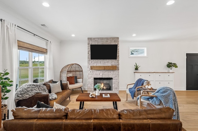 living room with light wood finished floors, a fireplace, visible vents, and recessed lighting