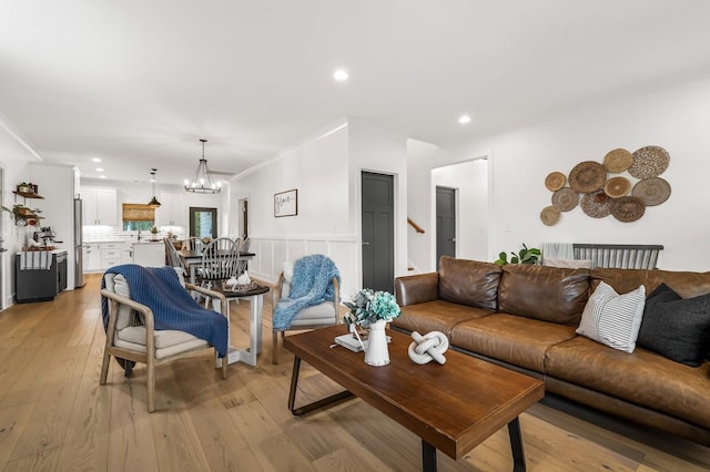 living area featuring a notable chandelier, wainscoting, light wood-style flooring, and recessed lighting