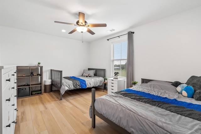 bedroom with a ceiling fan, visible vents, and light wood-style flooring