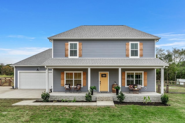 view of front of house featuring a shingled roof, concrete driveway, an attached garage, covered porch, and a front lawn