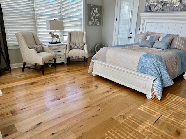 bedroom with baseboards and wood finished floors