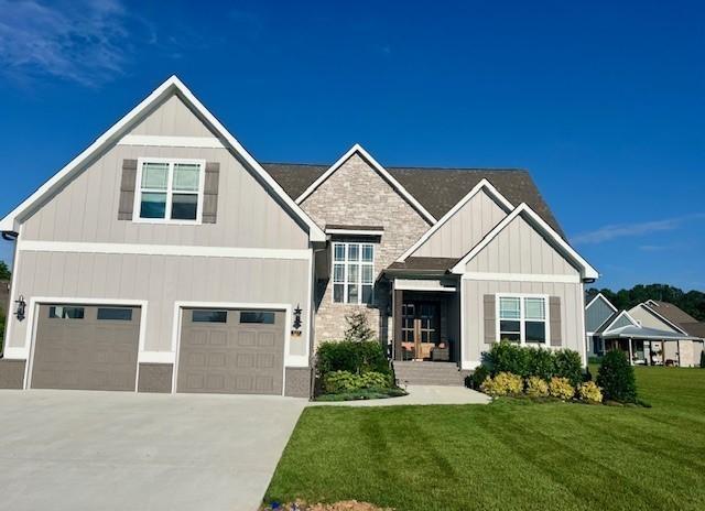 craftsman-style home featuring a garage, concrete driveway, board and batten siding, and a front yard