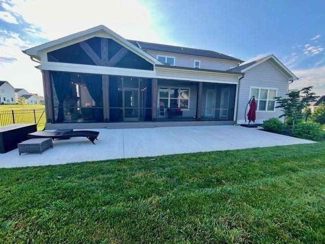 back of property featuring a sunroom, a patio, fence, and a lawn