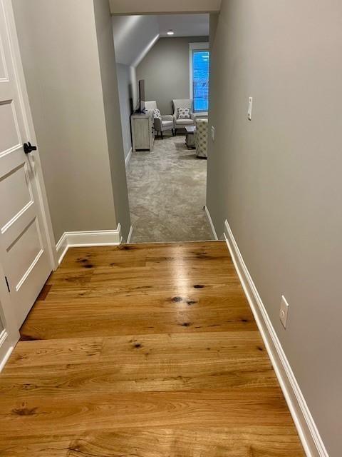 hall with baseboards and wood finished floors