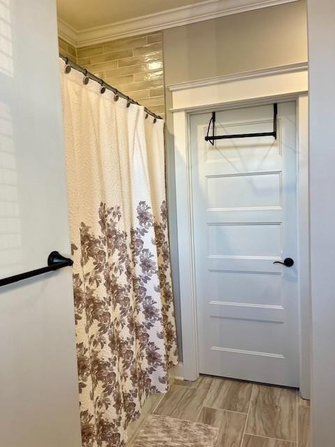 bathroom featuring a shower with shower curtain and crown molding